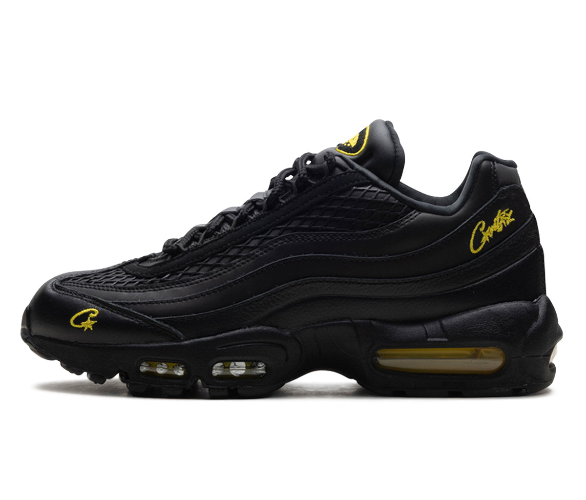 Black sneaker with yellow accents on a white background
