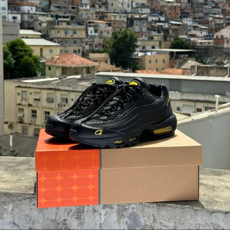Black sneakers with yellow accents on a box against a cityscape background