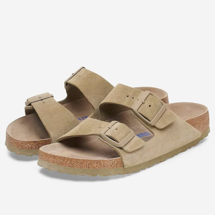Pair of tan sandals with double straps on a white background