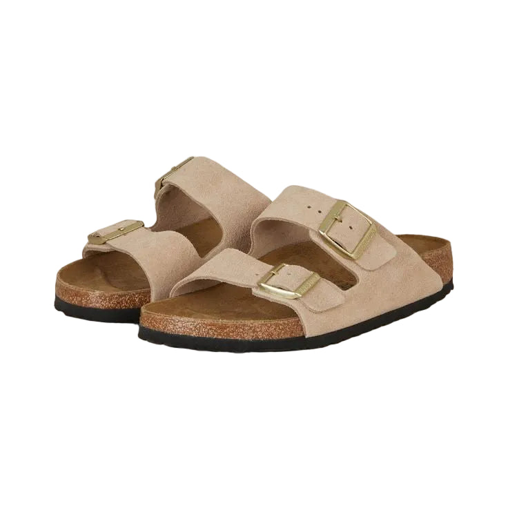 Pair of beige sandals with gold buckles on a white background