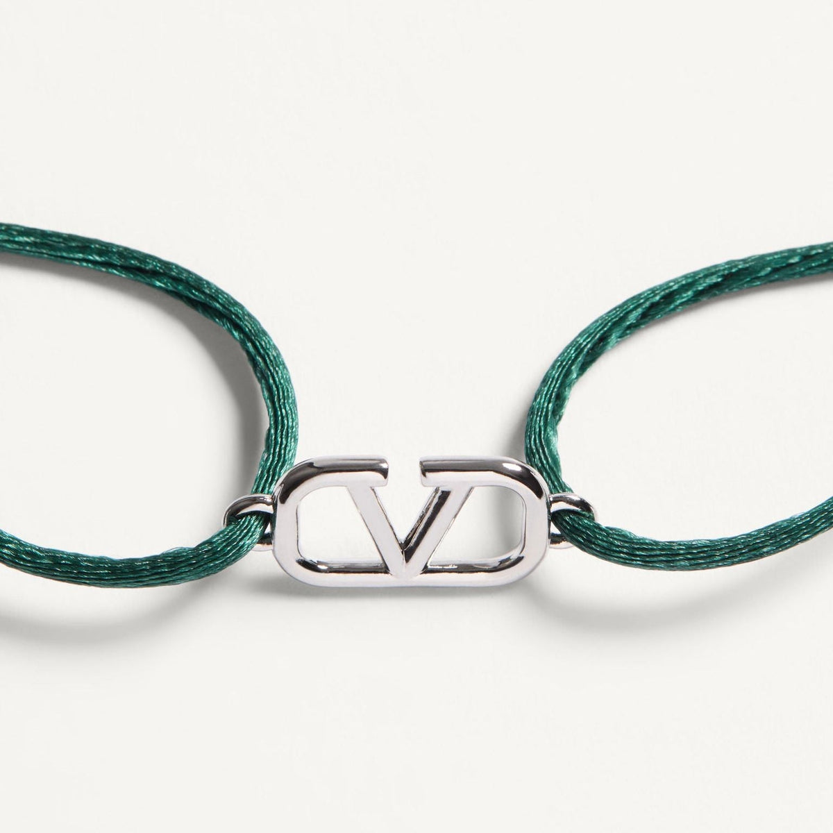 Green braided cord bracelet with a silver clasp on a white background