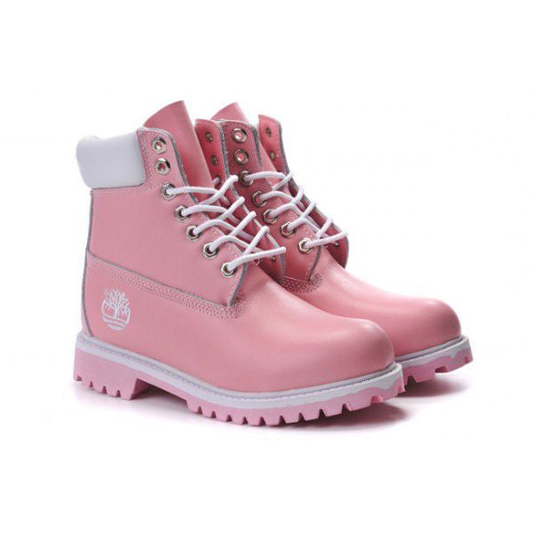A pair of pink Timberland lace-up boots with white laces, white collar lining, and a white Timberland logo on the side, set against a plain white background.