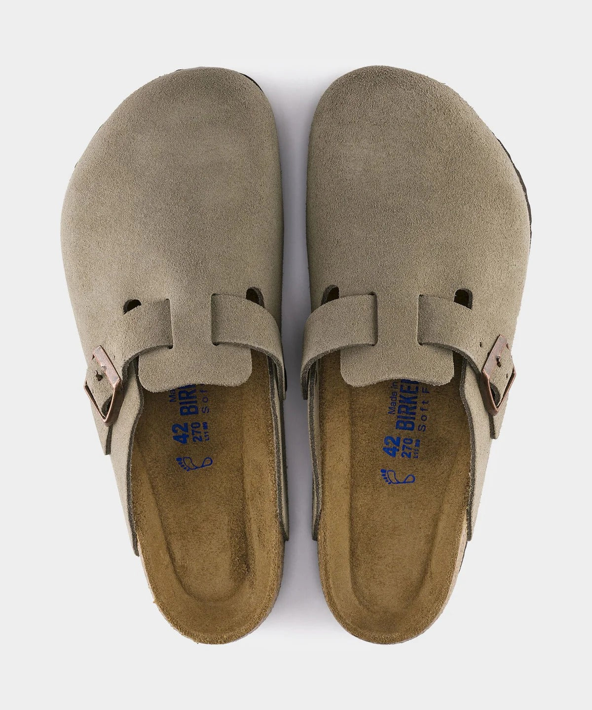 Pair of beige suede sandals with buckles on a white background