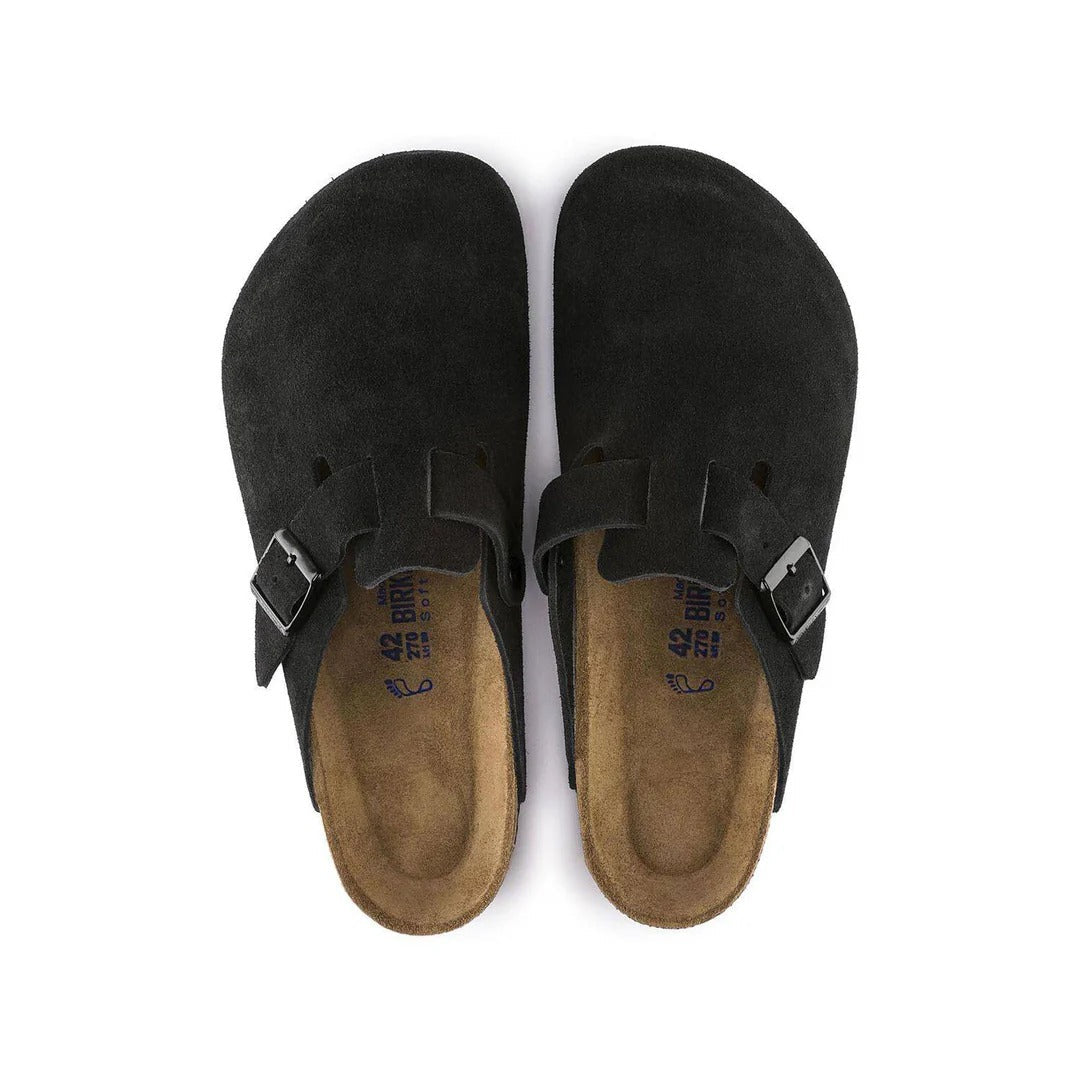 Pair of black suede sandals with brown soles on a white background