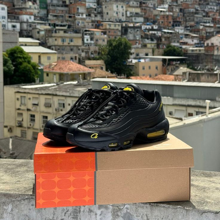 Black sneakers with yellow accents on a box against a cityscape background