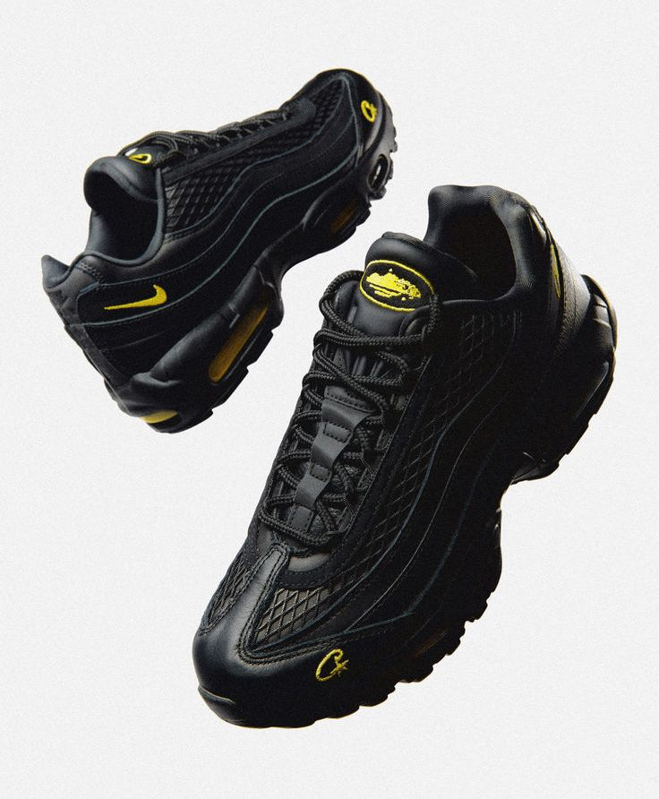 Black sneakers with yellow accents on a light gray background