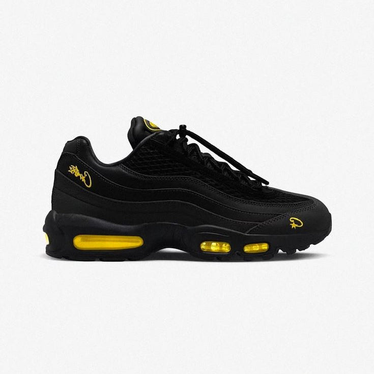 Black sneaker with yellow accents on a white background